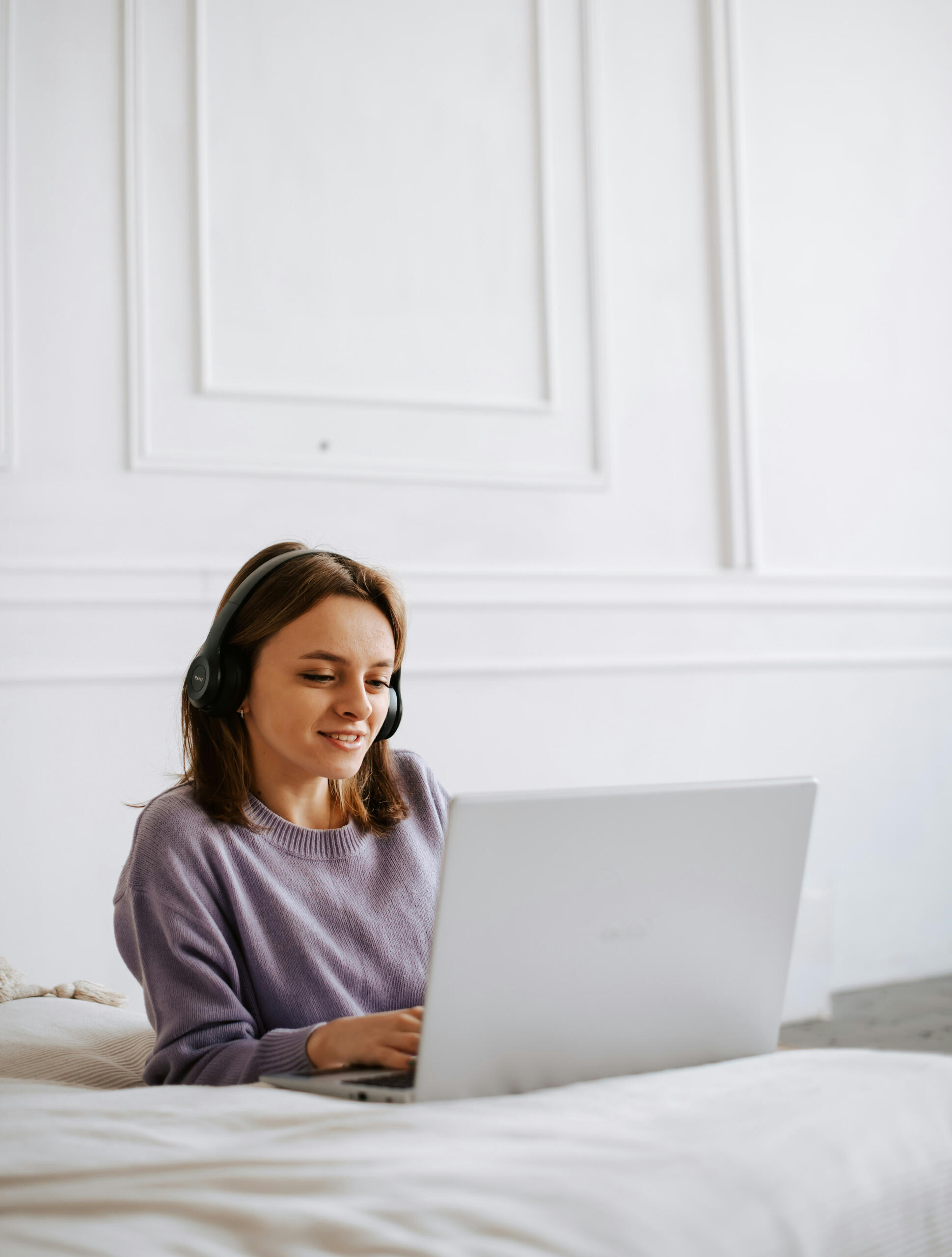 alt="Mujer recibiendo terapia online desde casa con auriculares y laptop"