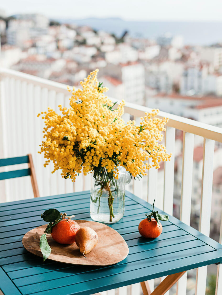 alt="Mesa con mimosas en una terraza. Sensación de calma y bienestar"