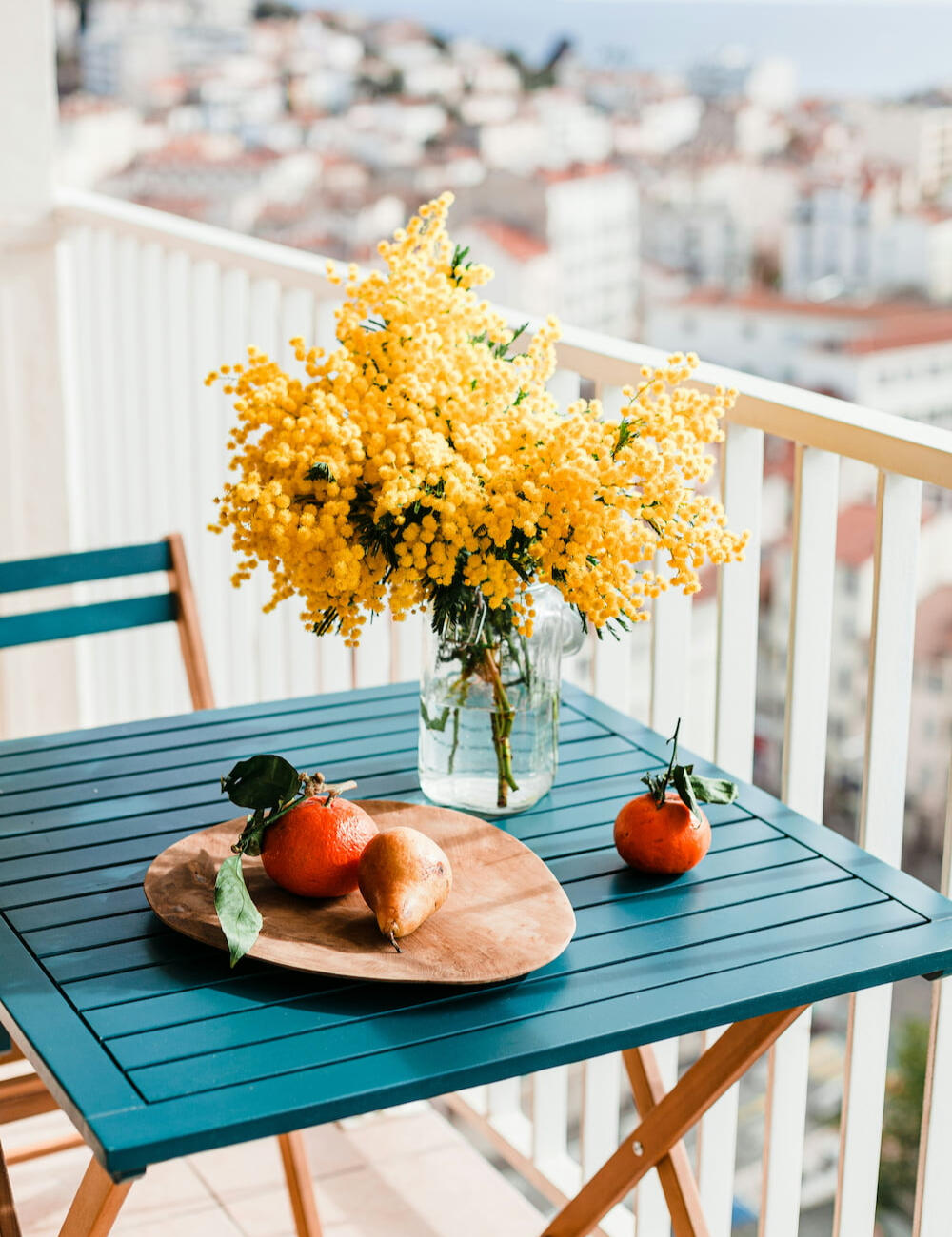 alt="Mesa con mimosas al sol, símbolo de calma y bienestar emocional. Mia Psicología: psicoterapia online en español, catalán y alemán desde Barcelona."